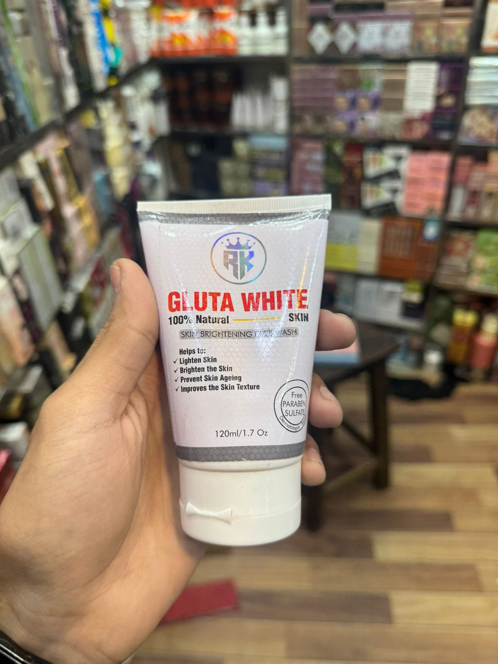 Hand holding a Gluta White skincare product in a store setting