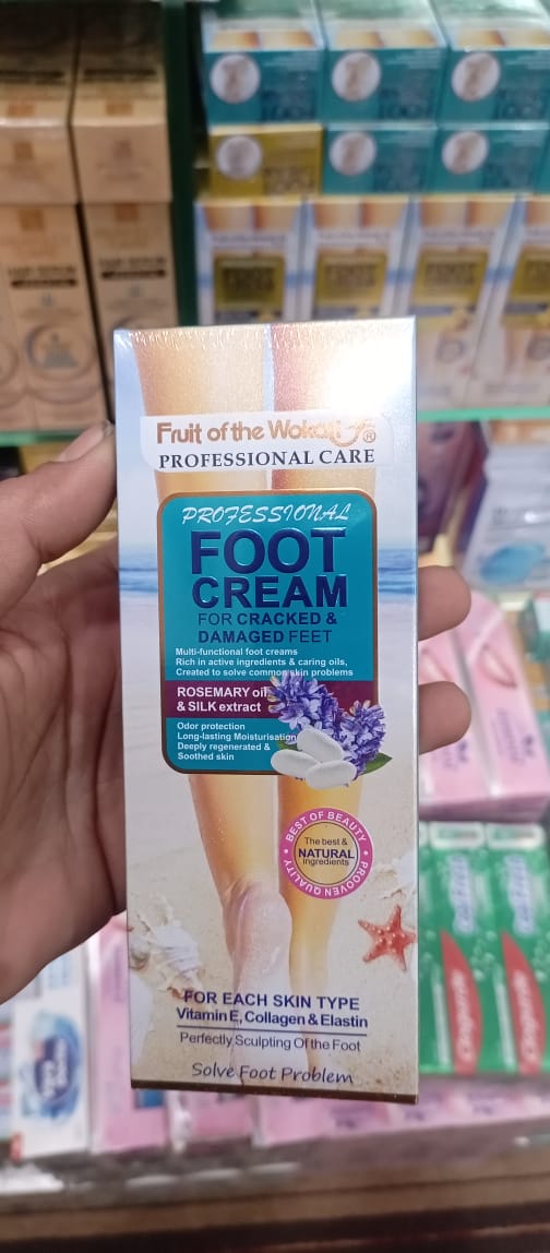 Foot cream packaging held by a hand with blurred product boxes in the background