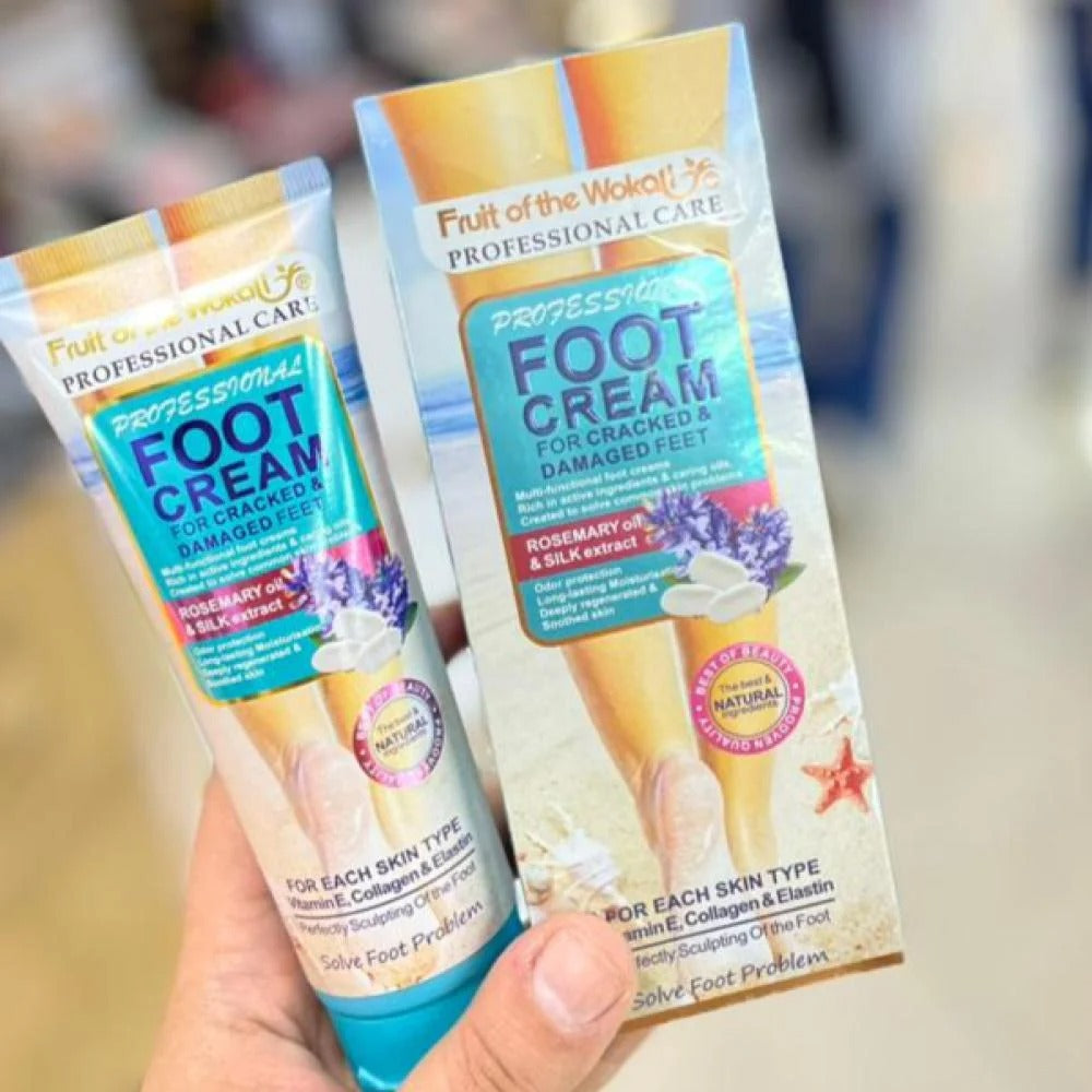 Two tubes of Fruit of the Wok Professional Care Foot Cream held in a hand with a blurred background.